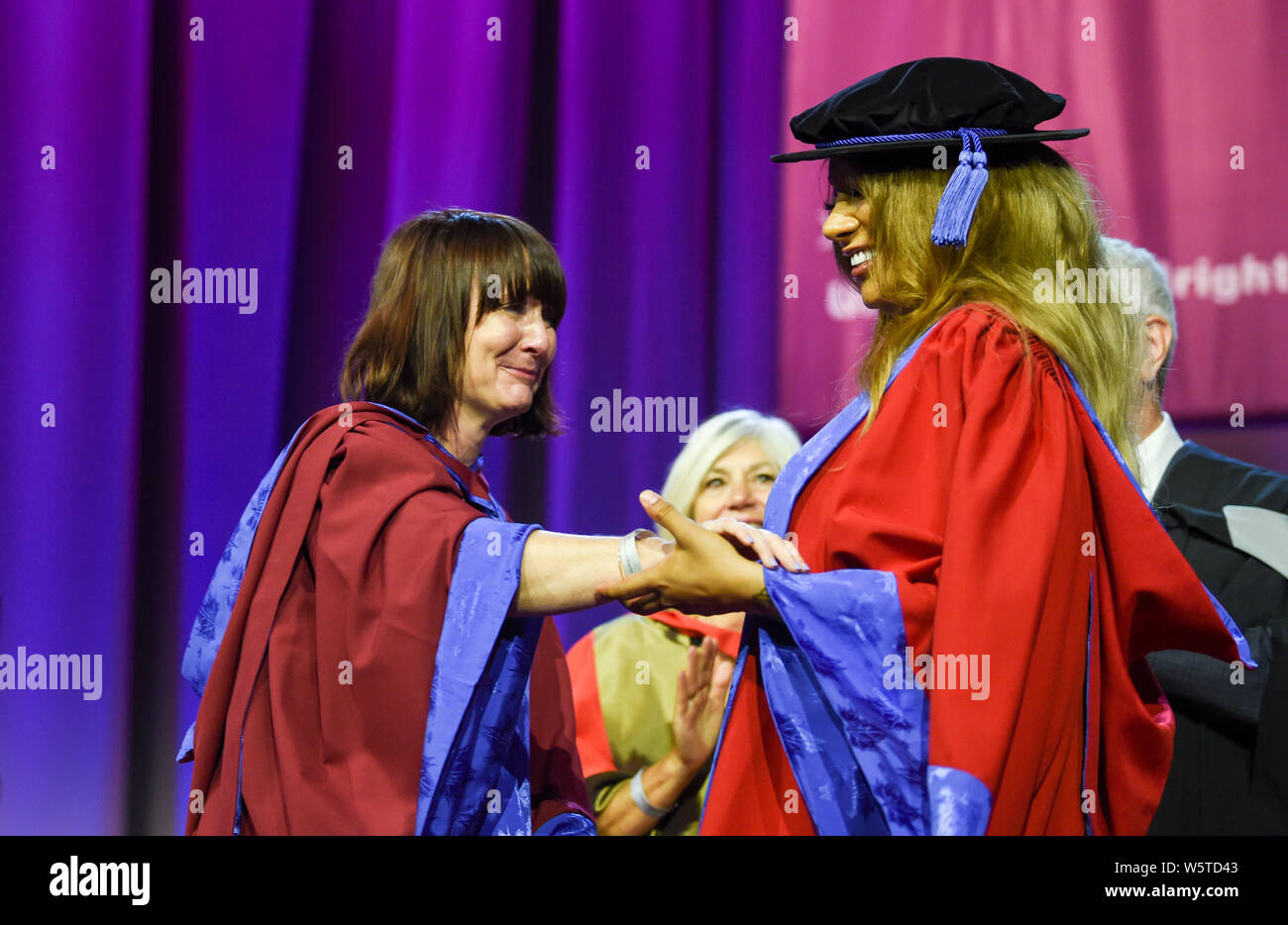Brighton UK 30th July 2019 - Famous transgender model Munroe Bergdorf (right) after receiving an honorary doctor of letters at the University of Brighton graduation ceremony greets her lecturer Dr Jessica Moriarty . Credit : Simon Dack / Alamy Live News Stock Photo