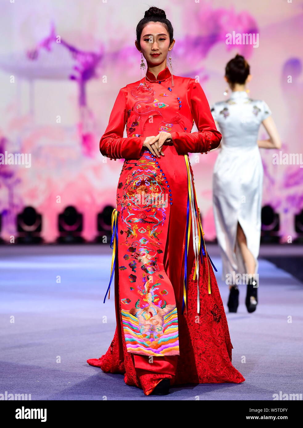 A model presents a new creation of cheongsam (qipao) made of embroideries  of Man ethnic group during a fashion show in Shenyang city, northeast  China' Stock Photo - Alamy