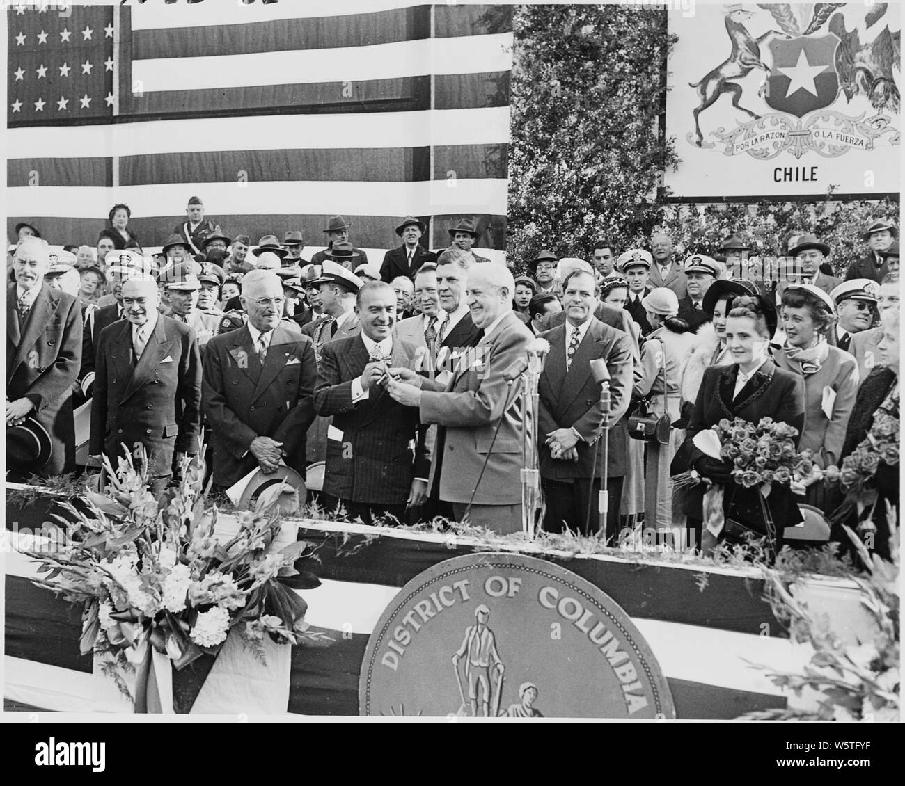 Photograph of Chilean President Gabriel Gonzalez Videla receiving the key to the city during his visit to Washington, as President Truman and other dignitaries look on. Stock Photo