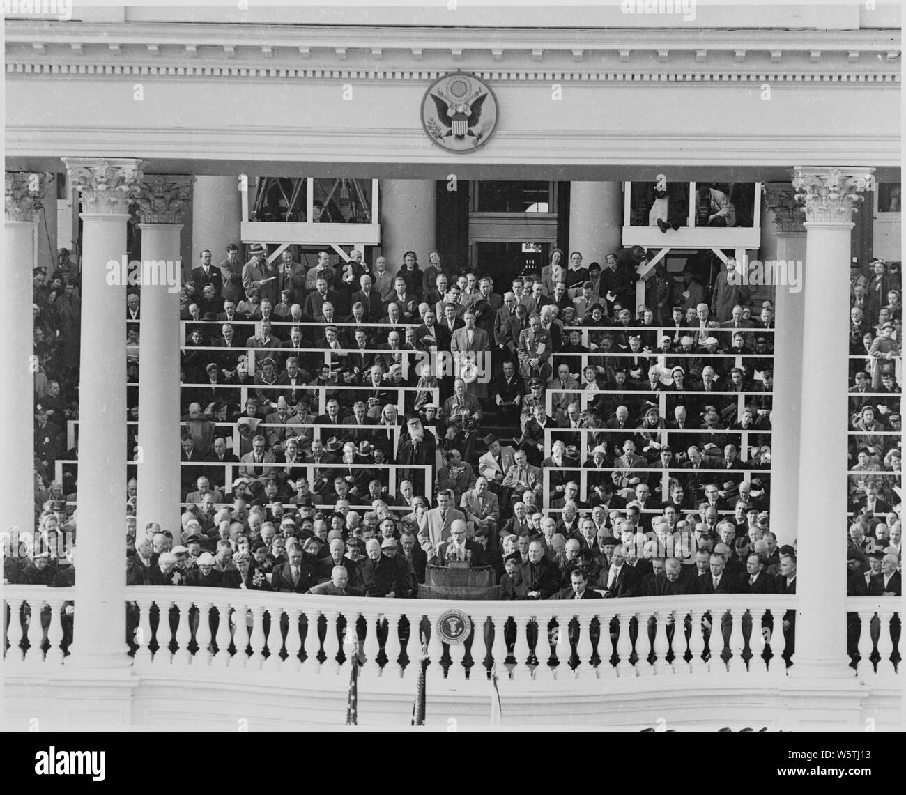 Photograph of Dwight D. Eisenhower delivering his Inaugural Address after taking the oath of office as President, as former Presidents Truman and Hoover, and other dignitaries, look on. Stock Photo