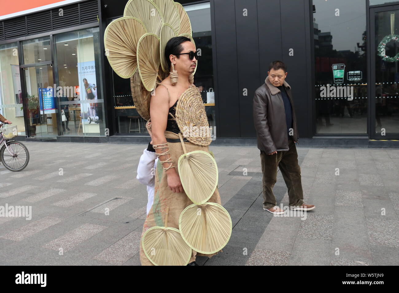 38-year-old Chinese man Dou Xiaogang dresses up in his self-made, environmentally friendly clothes made of cattail-leaf fans which people had thrown a Stock Photo