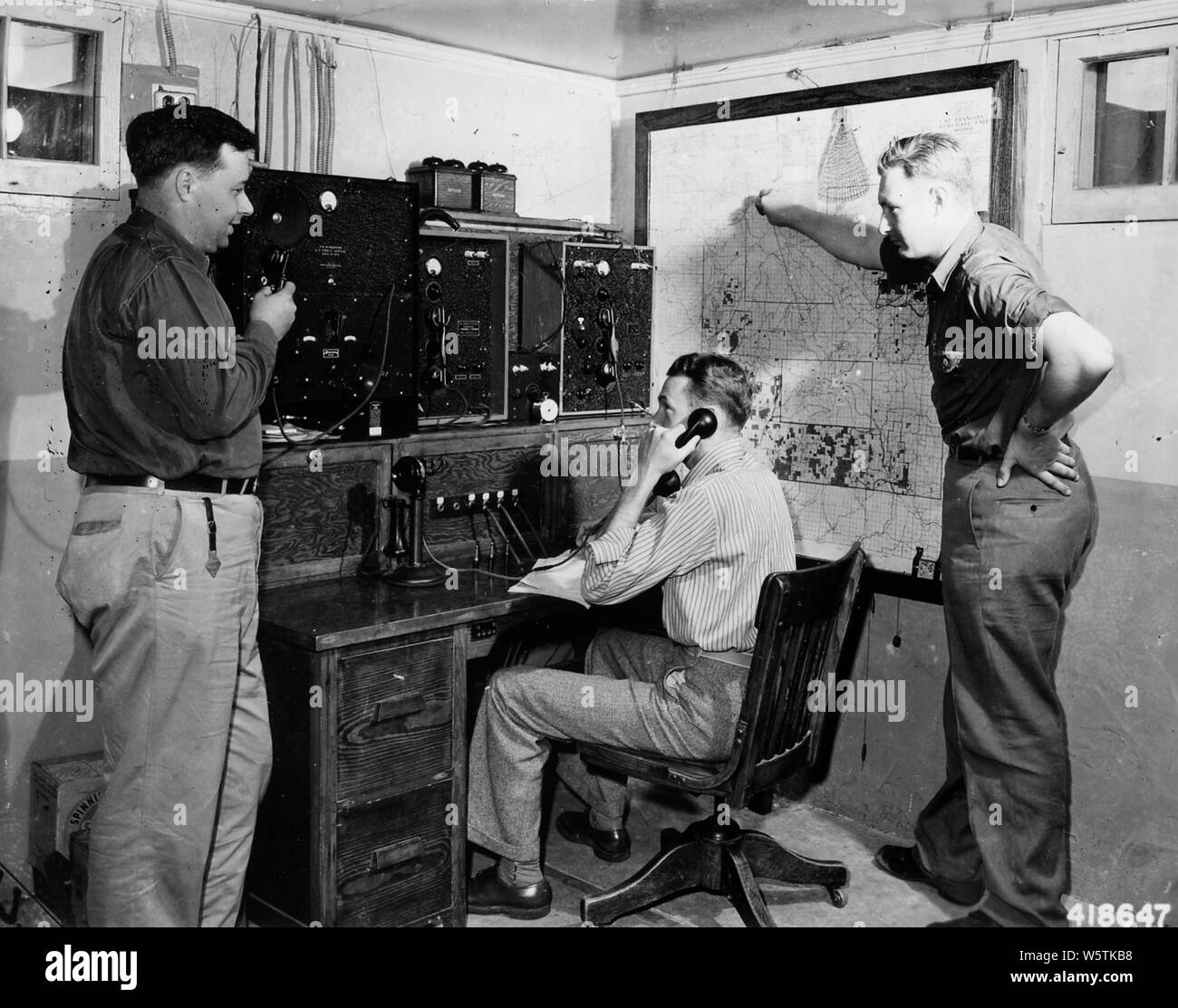 Photograph of Fire Dispatching Layout at Fredericktown Ranger Station; Scope and content:  Original caption: Fire dispatching layout at Fredericktown Ranger Station. Telephone to primary lookouts, Type M Radio to Type 3 PF sets with work and fire crews, type T radios to secondary and emergency lookouts and mobile crews equipped with S and SV radios. Left to righ. Stock Photo