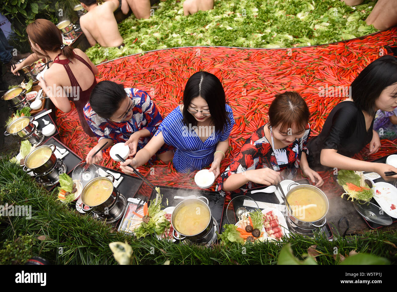 Visitors enjoy hot pots while soaking in a 'Yuan Yang' hotpot-style hot spring spa at the First World Hotel in Hangzhou city, east China's Zhejiang pr Stock Photo