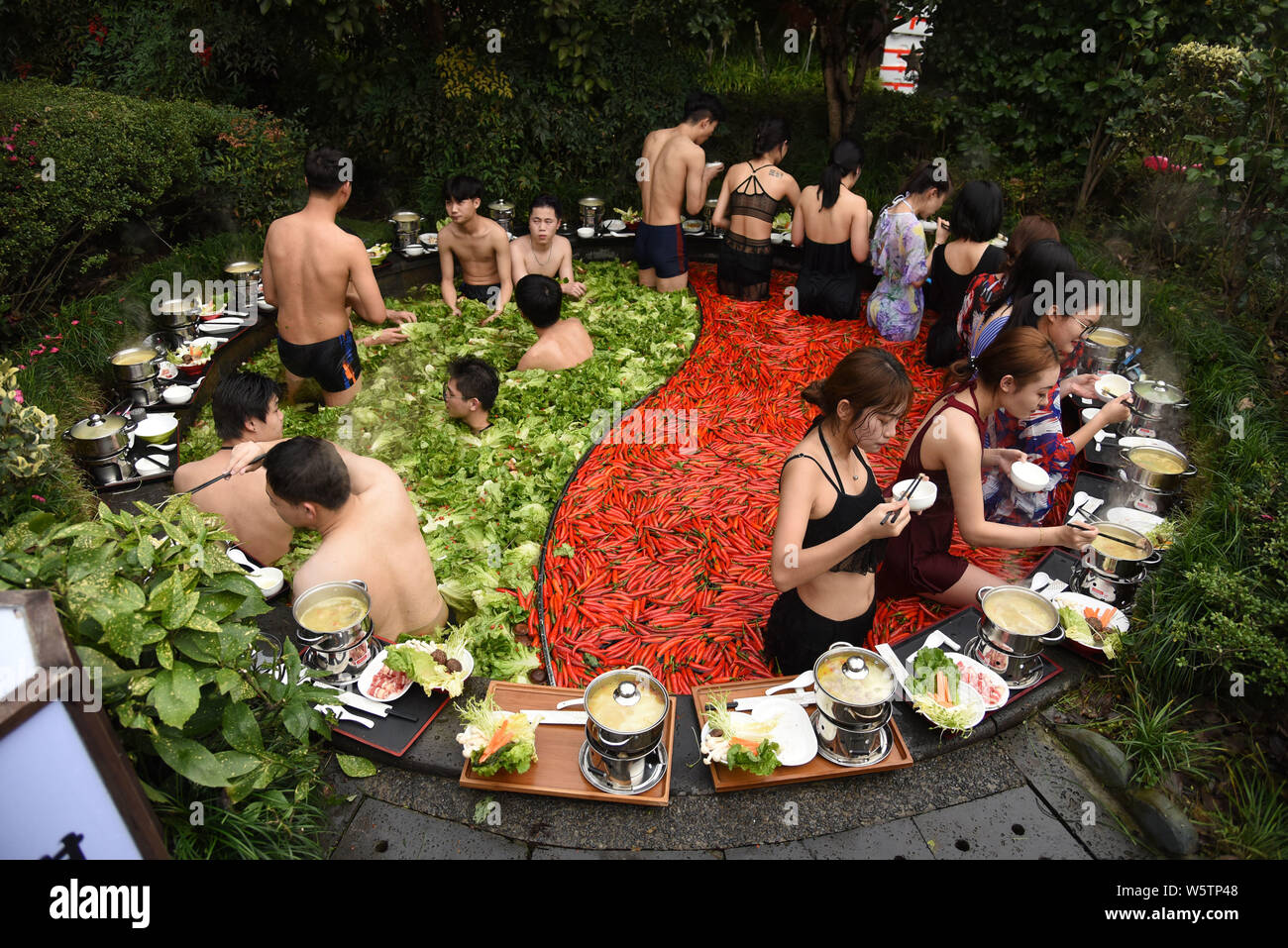 Visitors enjoy hot pots while soaking in a 'Yuan Yang' hotpot-style hot spring spa at the First World Hotel in Hangzhou city, east China's Zhejiang pr Stock Photo