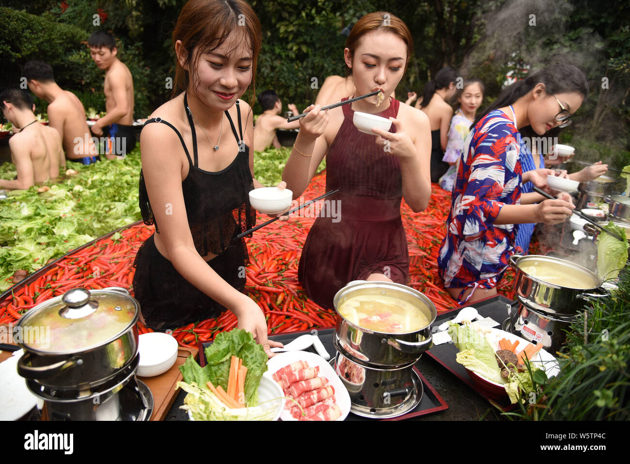 Visitors enjoy hot pots while soaking in a 'Yuan Yang' hotpot-style hot spring spa at the First World Hotel in Hangzhou city, east China's Zhejiang pr Stock Photo