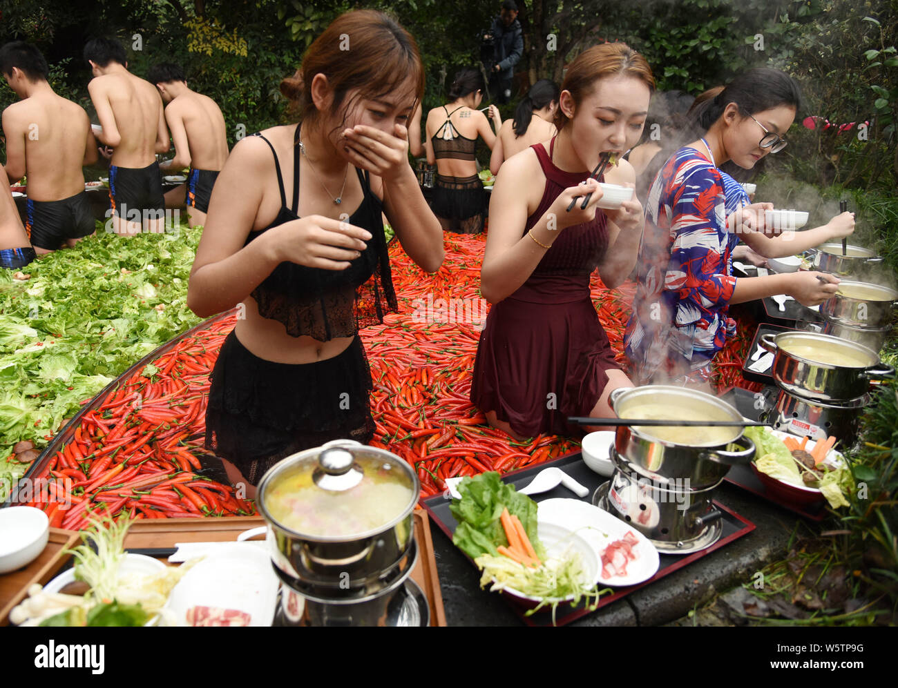 Visitors enjoy hot pots while soaking in a 'Yuan Yang' hotpot-style hot spring spa at the First World Hotel in Hangzhou city, east China's Zhejiang pr Stock Photo