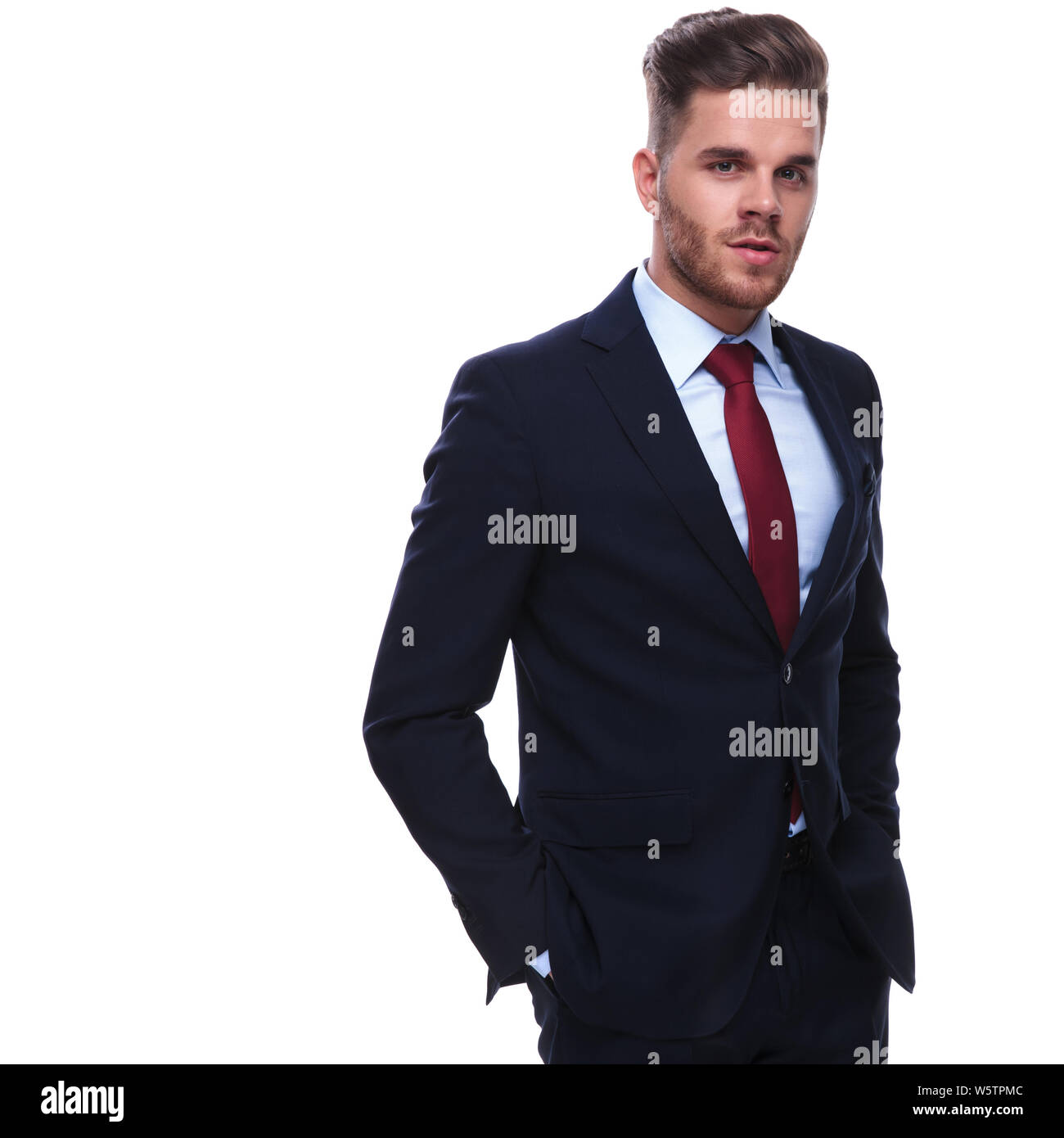 portrait of handsome relaxed businessman in navy suit standing on white ...