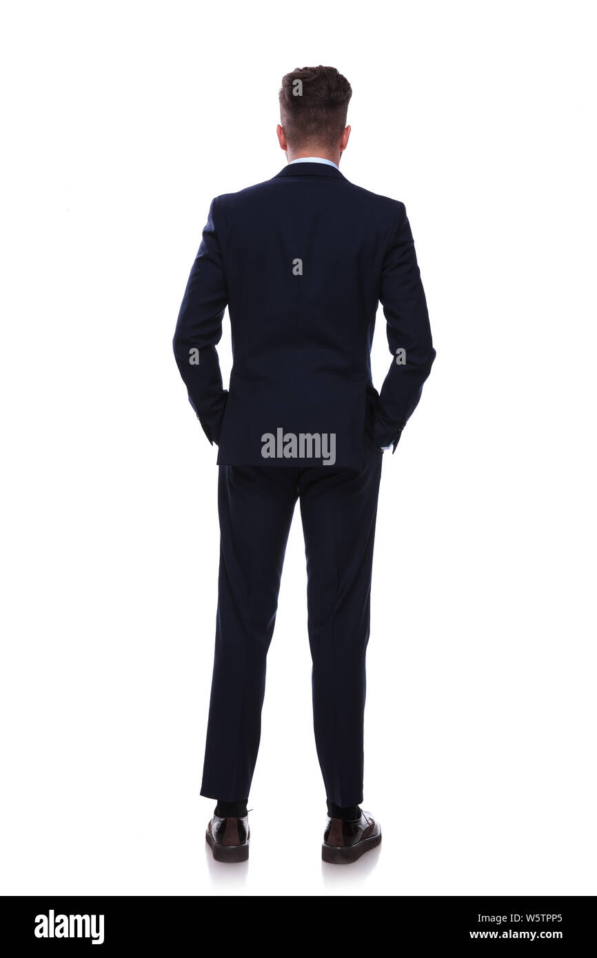 back view of relaxed businessman in navy suit standing on white ...