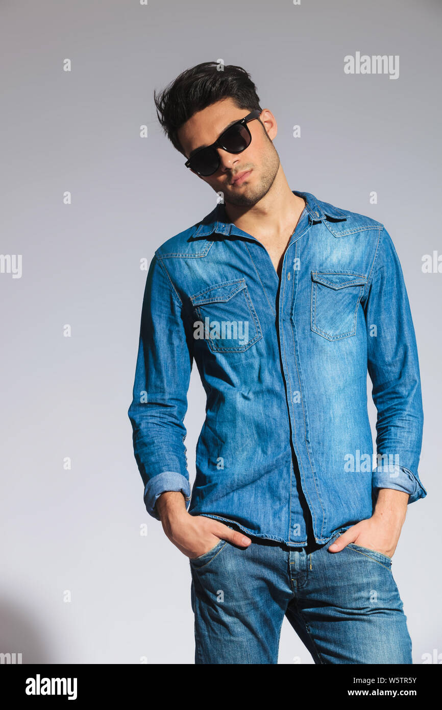 cool casual man with sunglasses standing with hands in pockets on light ...