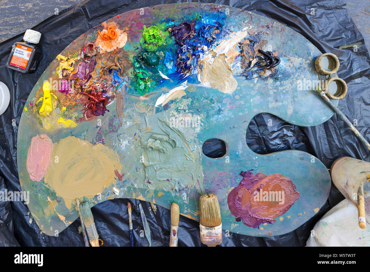 A Painter’s Palette with Paints and Brushes. Stock Photo