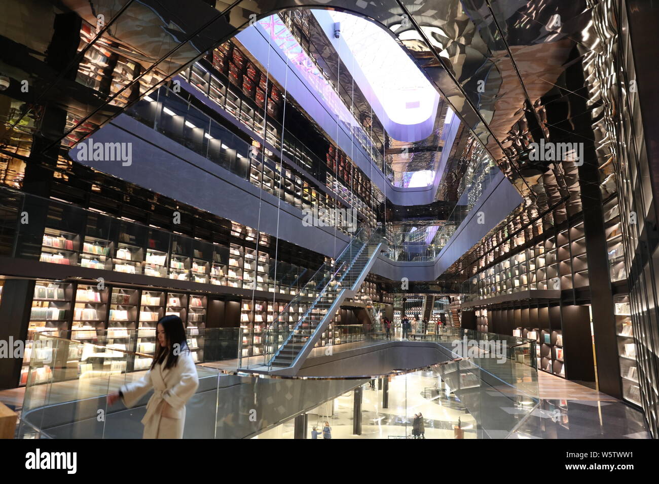 Books are placed on the four-storey-high book wall decorated with glass with a height of 18 meters at a shopping mall in Xi'an city, northwest China's Stock Photo