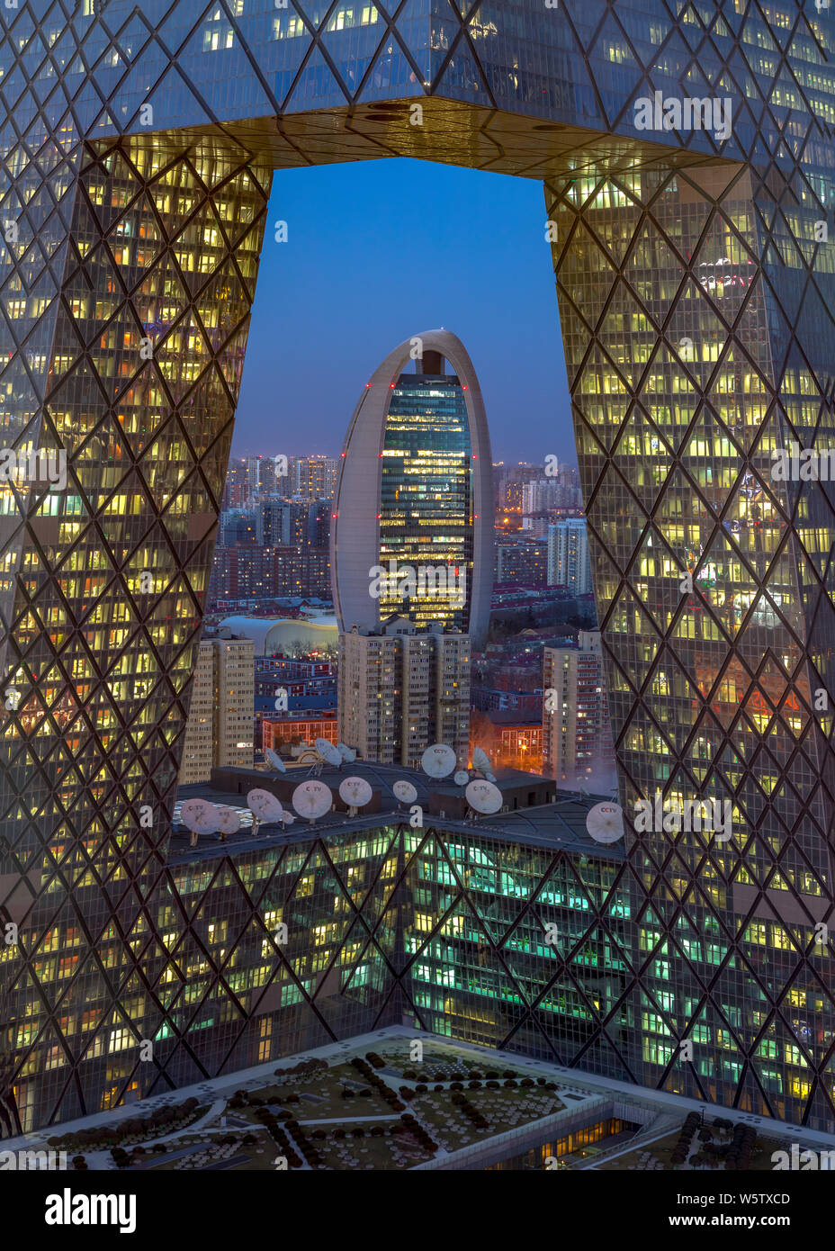A night view of the new headquarters building of the People's Daily seen through the new CCTV Tower in the Central Business District (CBD) in Beijing, Stock Photo