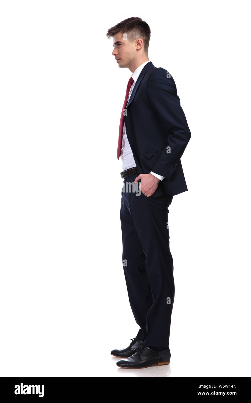 side view of relaxed businessman wearing a navy suit and red tie waiting in  line while standing on white background with hands in pockets Stock Photo -  Alamy