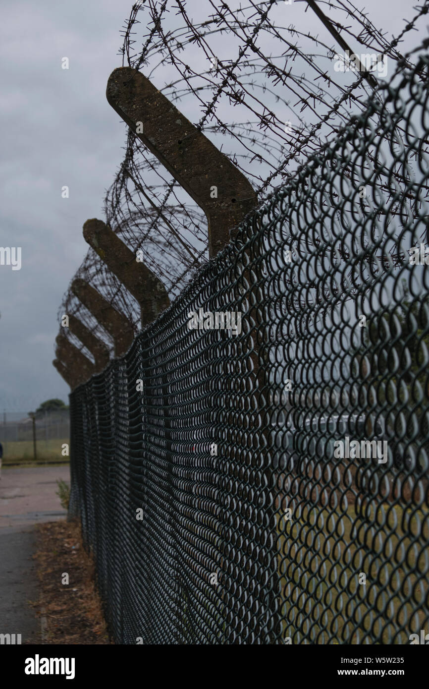 Barbed wire fence on stormy day Stock Photo