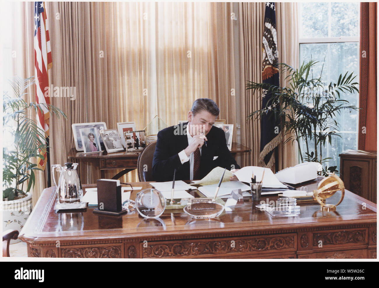 Photograph of President Reagan working at his Oval Office desk Stock ...