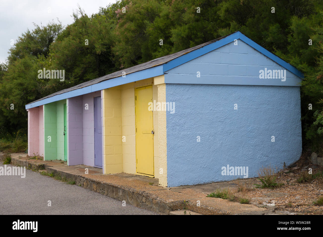 Brightly painted concrete beach huts in Folkestone Kent Stock Photo