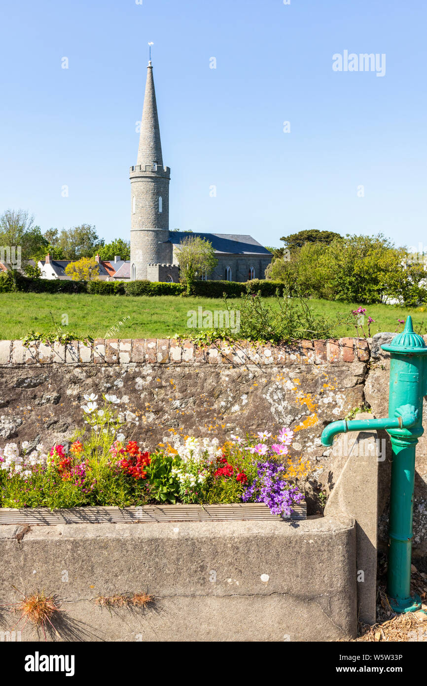 Flowers in an old water trough next to a pump in Torteval, Guernsey, Channel Islands UK Stock Photo