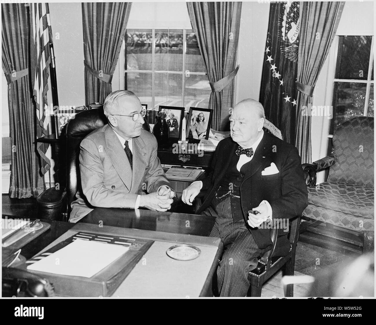 Photograph of President Truman conferring with the Prime Minister of
