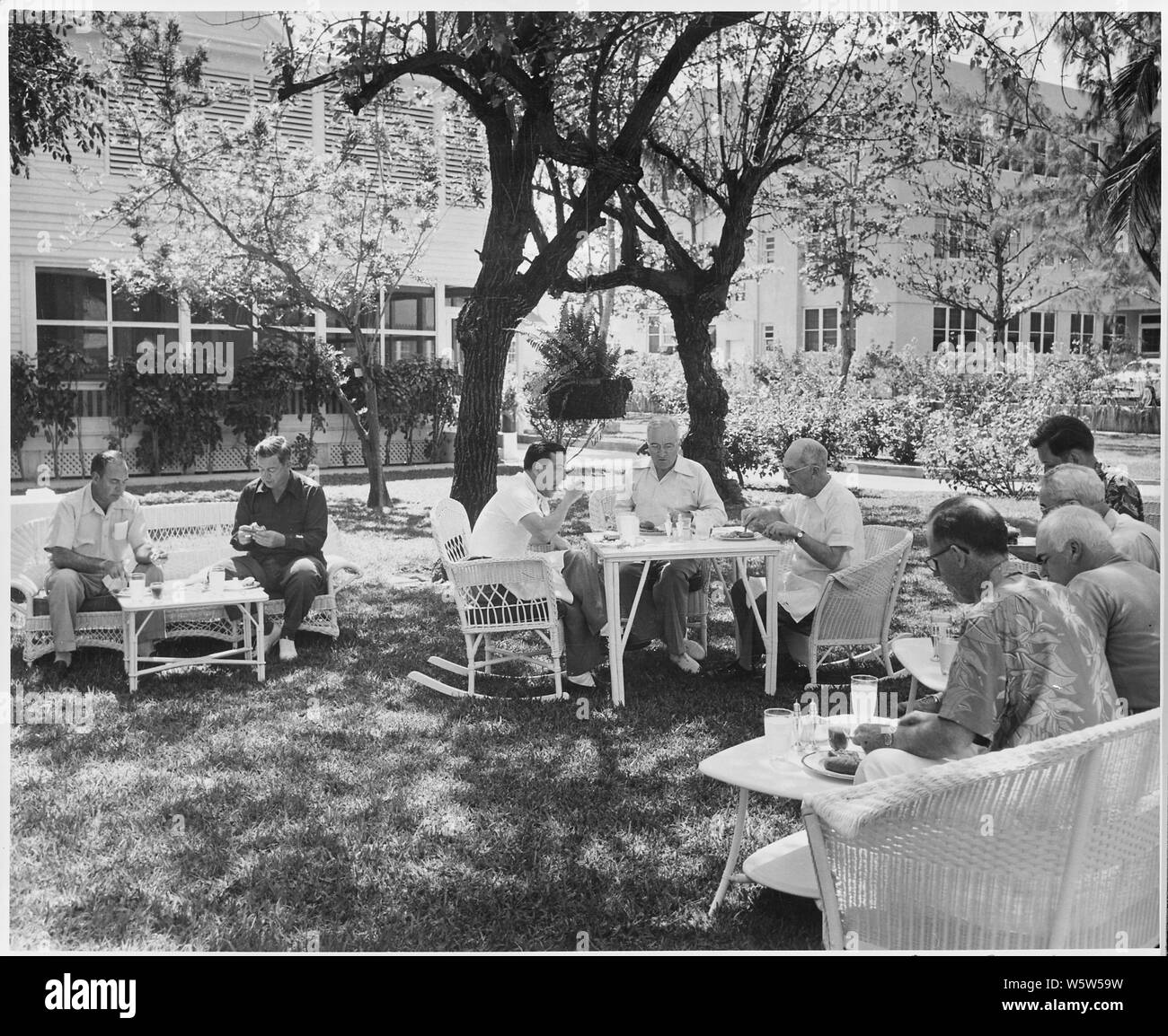 Photograph of president truman eating a picnic lunch on the lawn of the