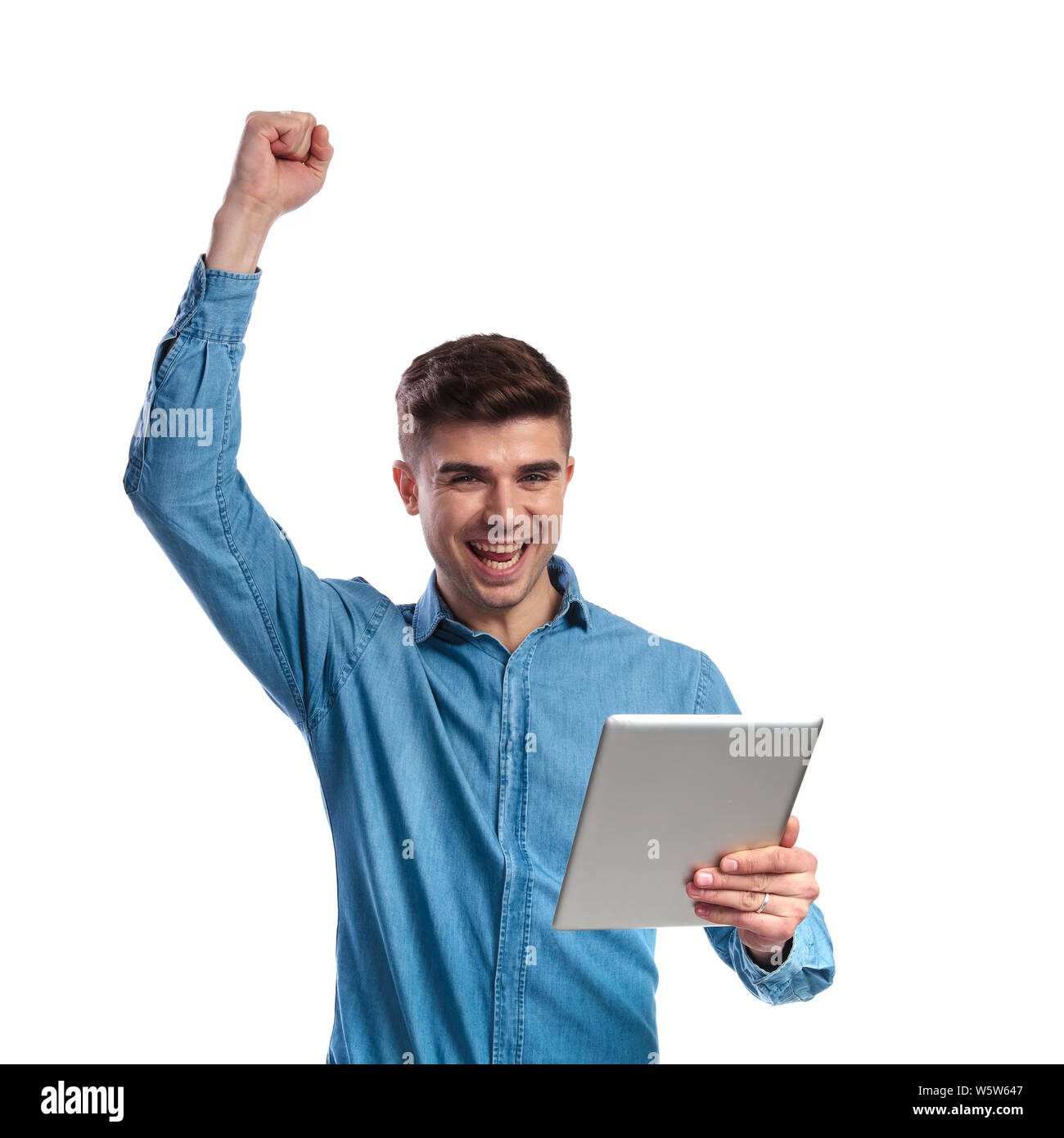 young man holding tablet is celebrating success with hand in the air on  white background Stock Photo - Alamy