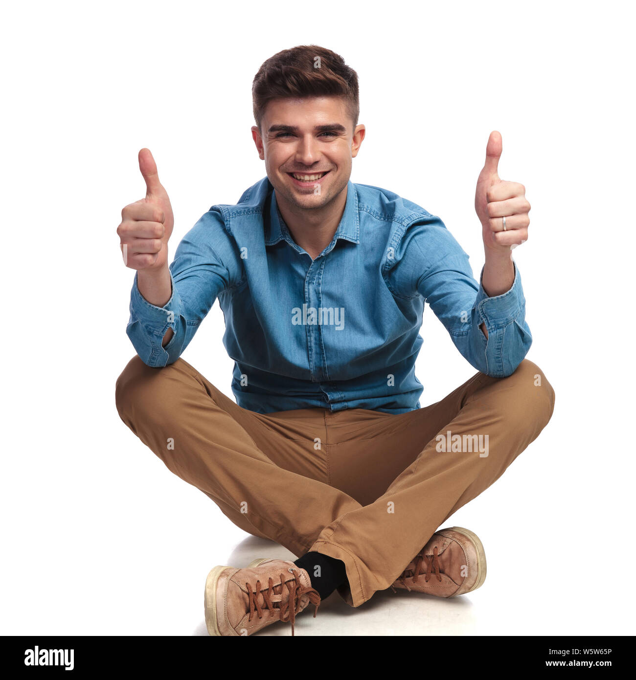 casual man sitting on the floor makes ok sign on white background Stock ...