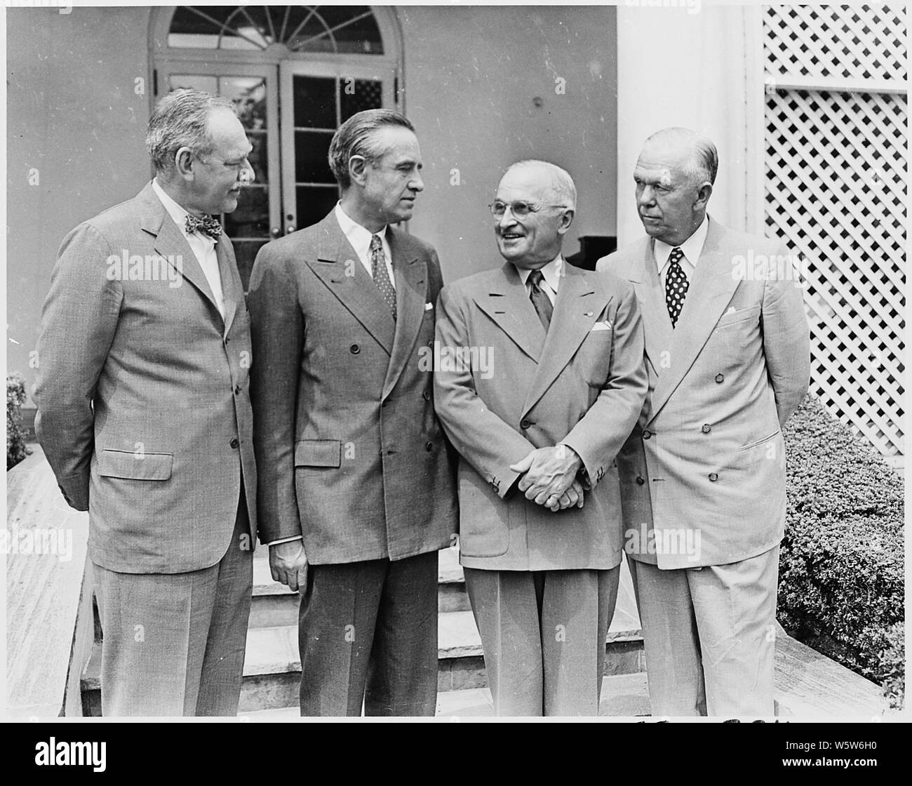 Photograph of President Truman in the White House Rose Garden with W. Averell Harriman, Special Assistant to the President, prior to Harriman's departure for Iran on a mission aimed at resolving a dispute between British oil interests and the Iranian government: (left to right) Secretary of State Dean Acheson; Harriman; the President; Secretary of Defense George C. Marshall. Stock Photo