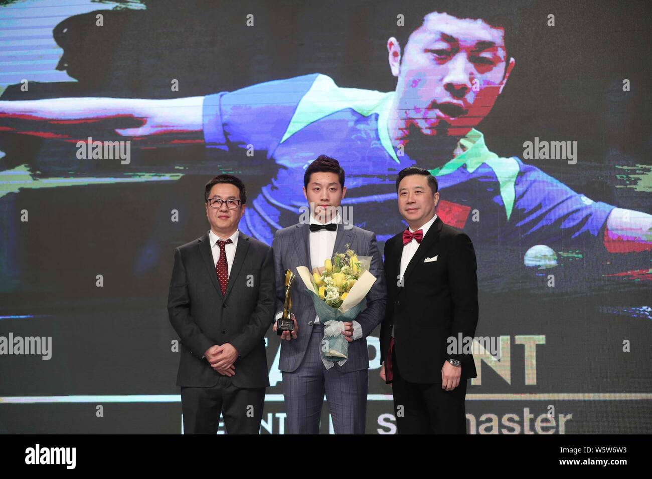 Chinese table tennis player Xu Xin, center, poses with his 'Star Point Award' trophy during the Star Awards of the 2018 International Table Tennis Fed Stock Photo