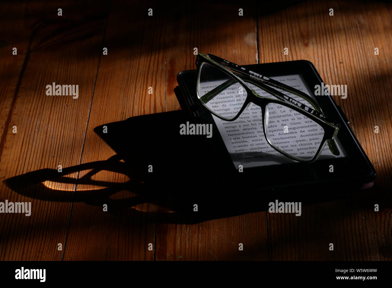 Electronic book and reading glasses. An anti-reflex electronic ink device that provides a comfortable reading experience on the device. Stock Photo