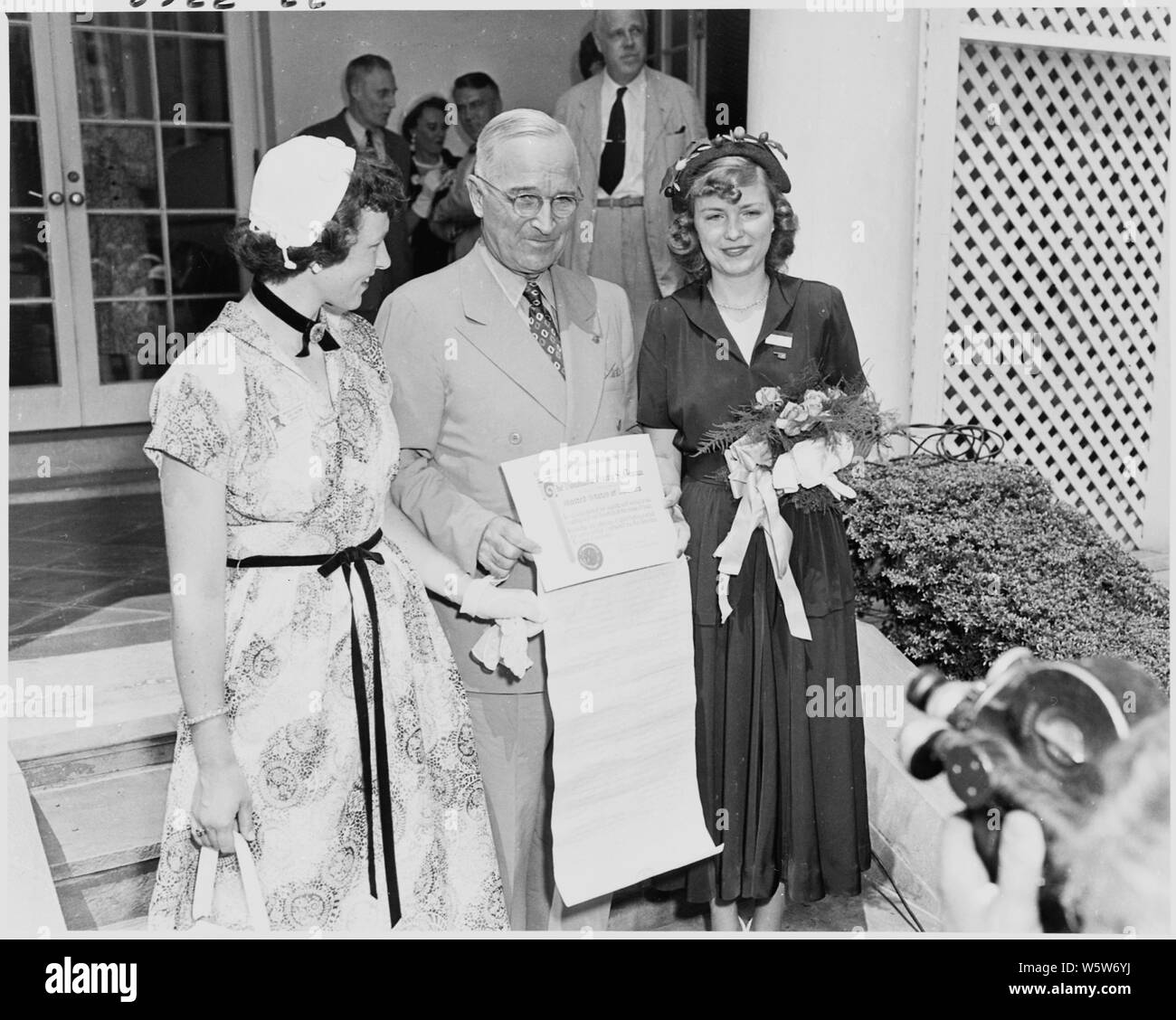 Photograph of President Truman outside the White House receiving a certificate from representatives of Girls Nation, a citizenship organization sponsored by the American Legion Auxiliary. Stock Photo