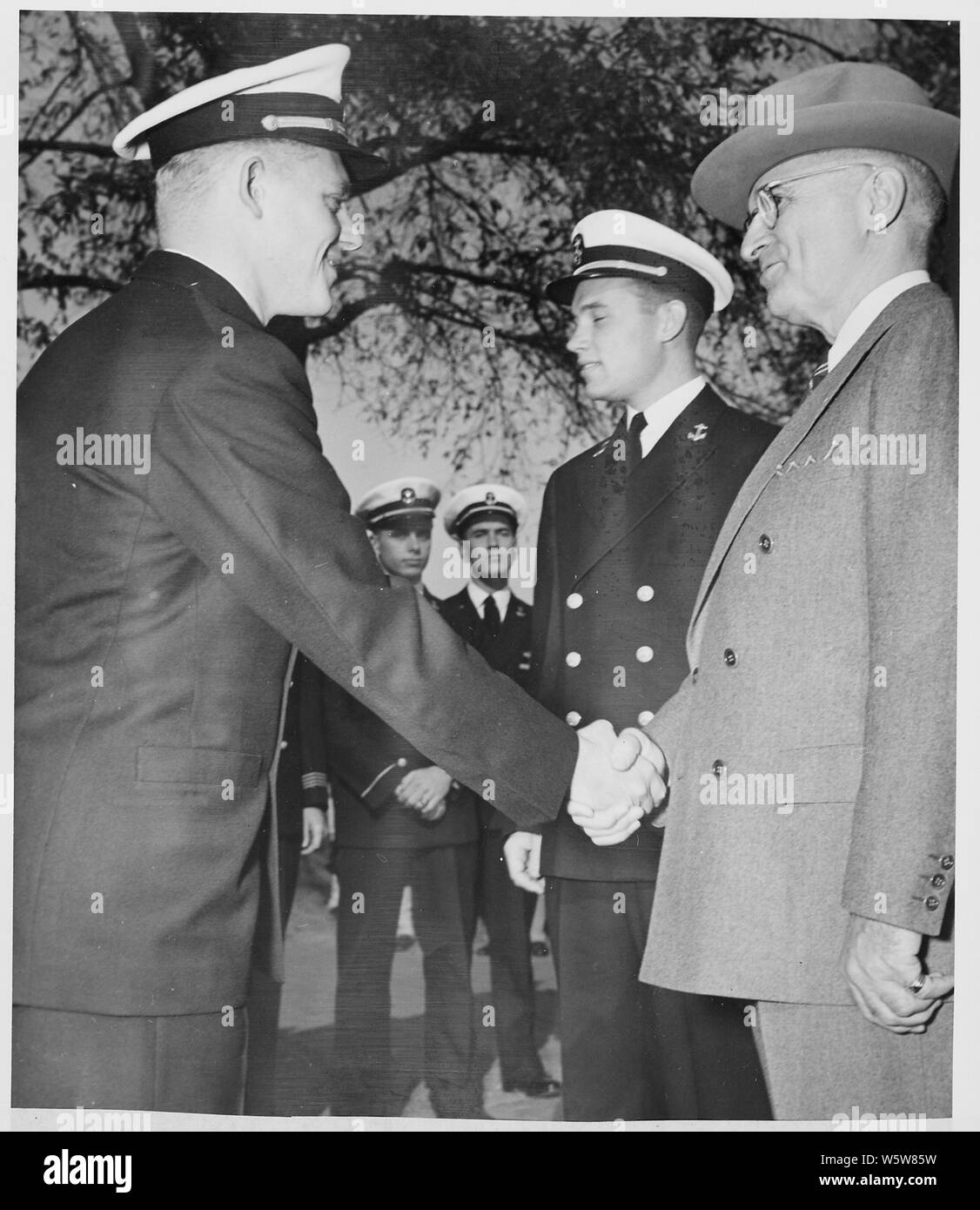 Photograph of President Truman shaking hands with Midshipman Charles