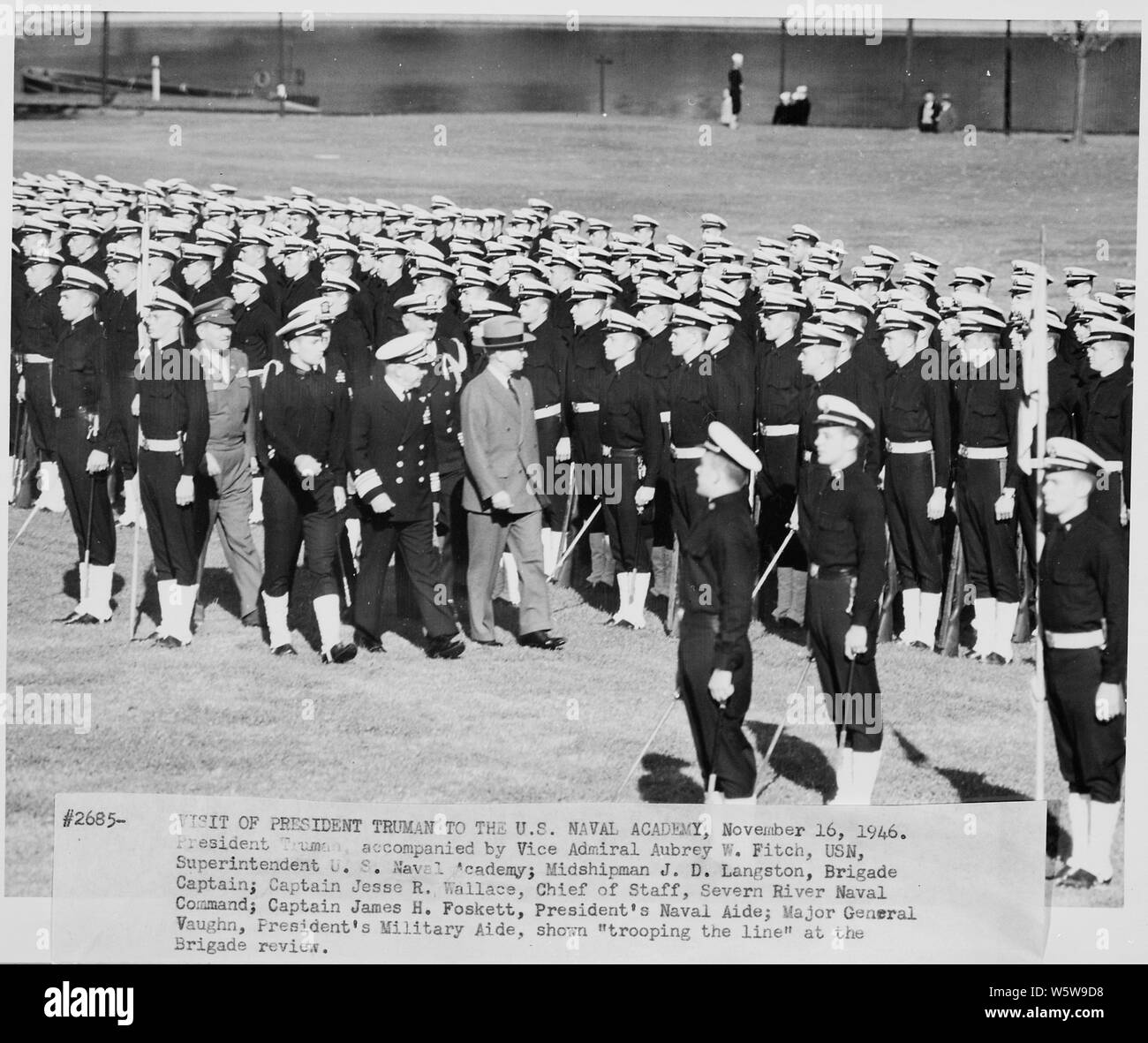 Photograph of President Truman trooping the line of Midshipmen at the Brigade review, during his visit to the U.S. Naval Academy, accompanied by Vice Admiral Aubrey Fitch, Superintendent of the Academy; Midshipman J. D. Langston, Brigade Captain; Captain Jesse R. Wallace, Chief of Staff, Severn River Naval Command; Captain James Foskett, Naval Aide to the President; and General Harry Vaughan, Military Aide to the President. Stock Photo