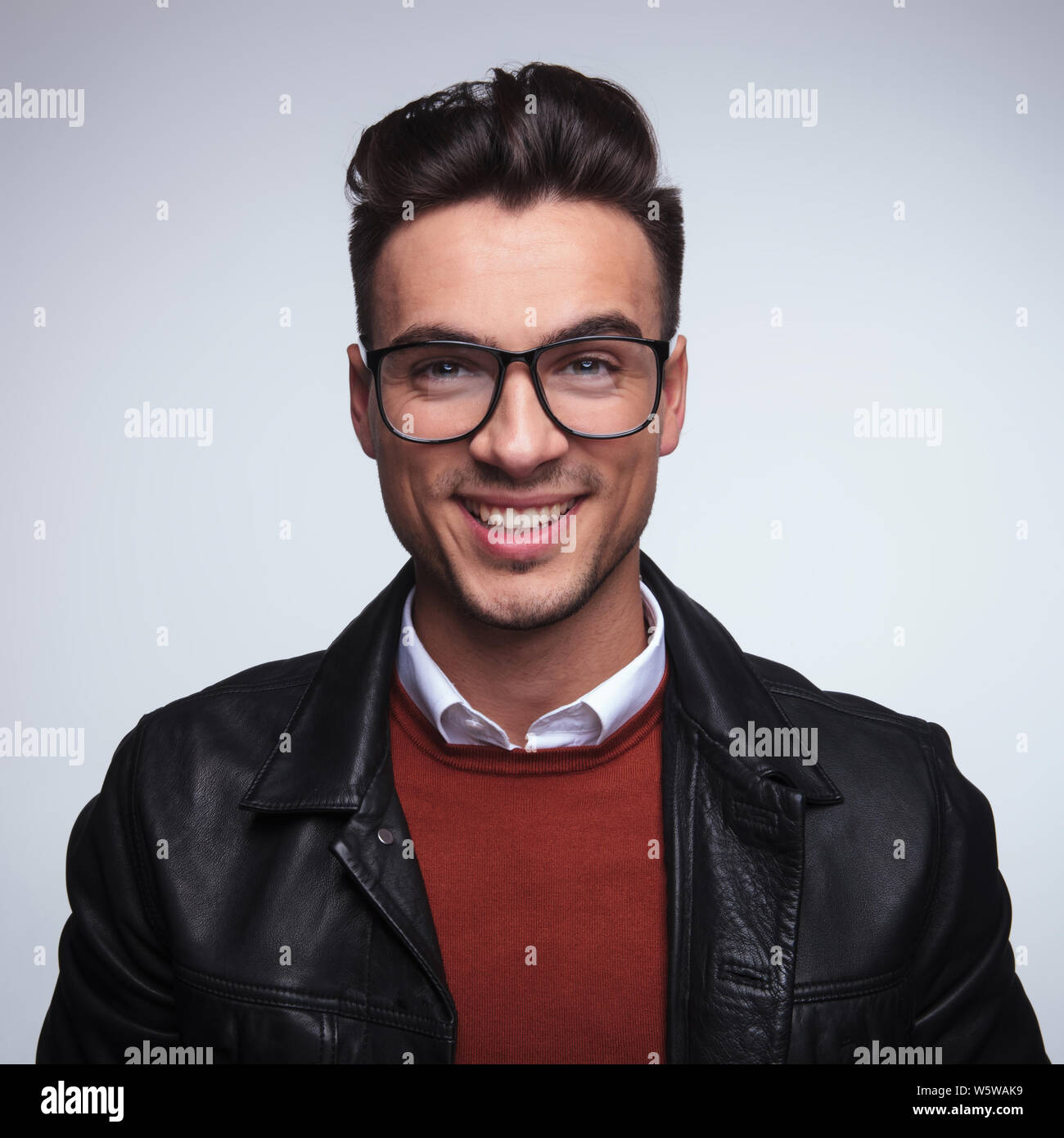portrait of a laughing young man wearing glasses in studio Stock Photo ...