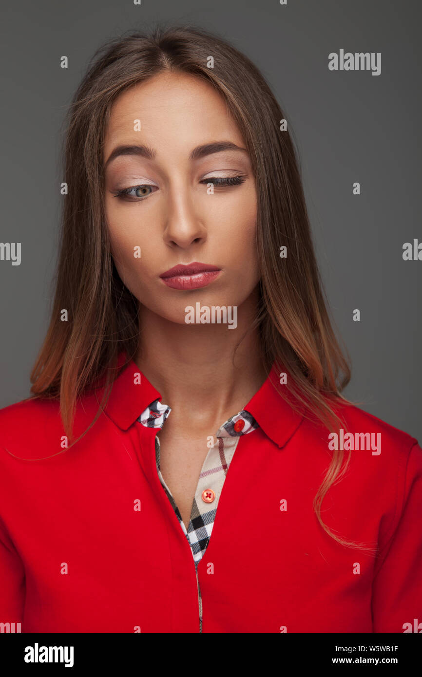 young caual woman making a stupid face on grey background Stock Photo