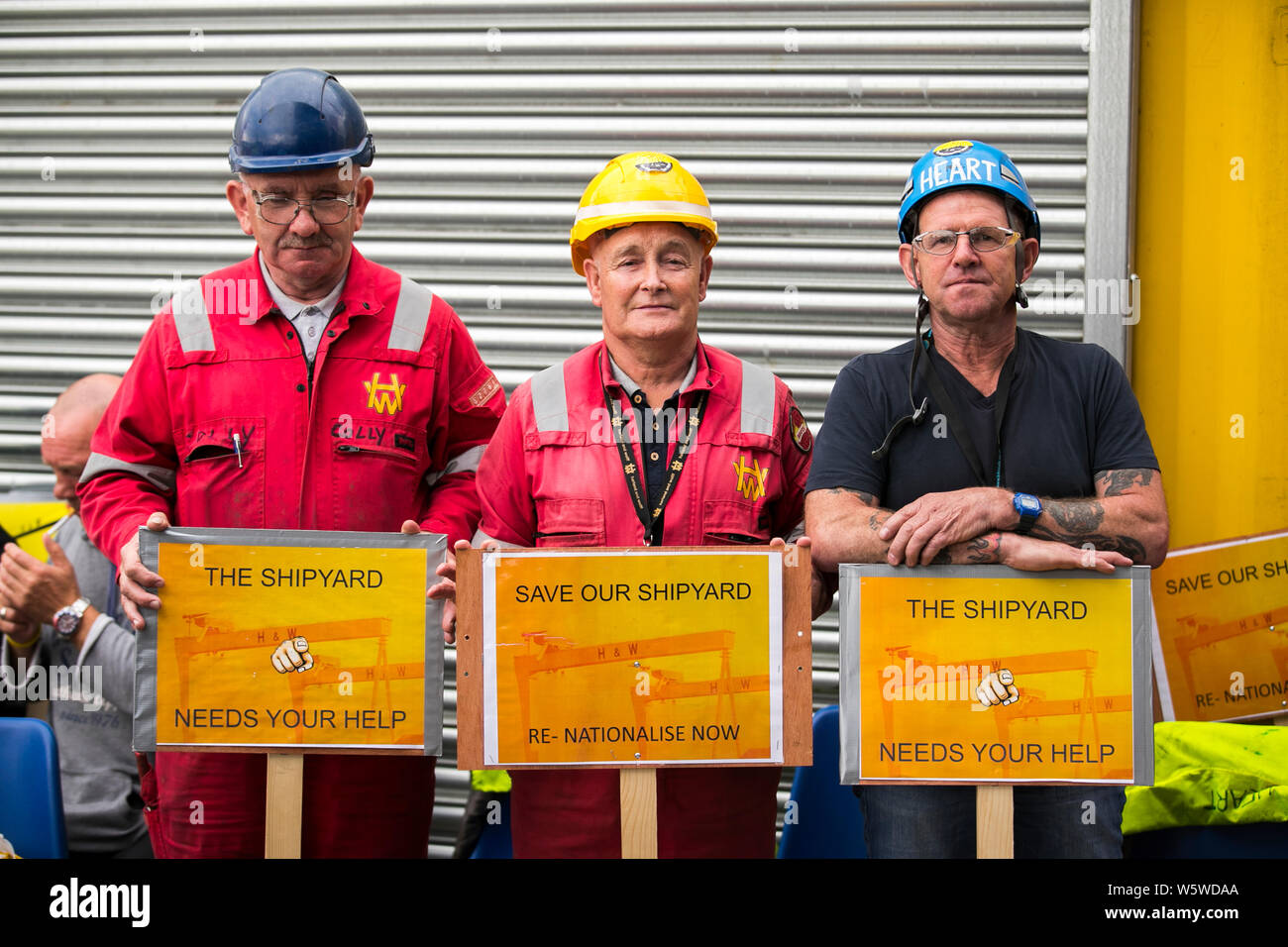 (Left to right) Harland and Wolff employees Colin McLoughlin, rigger, Tommy Stewart, foreman ship repairman and Gary ‘Heart’ Fleming, ship repair fitter, during a rally to save the shipyard, as an additional five days has been made available to save an under-threat Belfast shipyard following the delay of a visit by administrators. Stock Photo