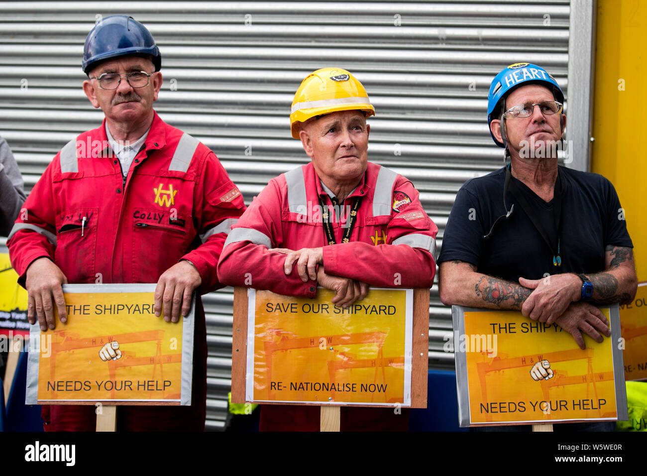 (Left to right) Harland and Wolff employees Colin McLoughlin, rigger, Tommy Stewart, foreman ship repairman and Gary ‘Heart’ Fleming, ship repair fitter, during a rally to save the shipyard, as an additional five days has been made available to save an under-threat Belfast shipyard following the delay of a visit by administrators. Stock Photo