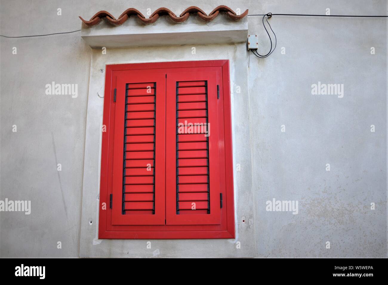 Closed Red Shutters On White Wall Of Typical Of Mediterranean Sea