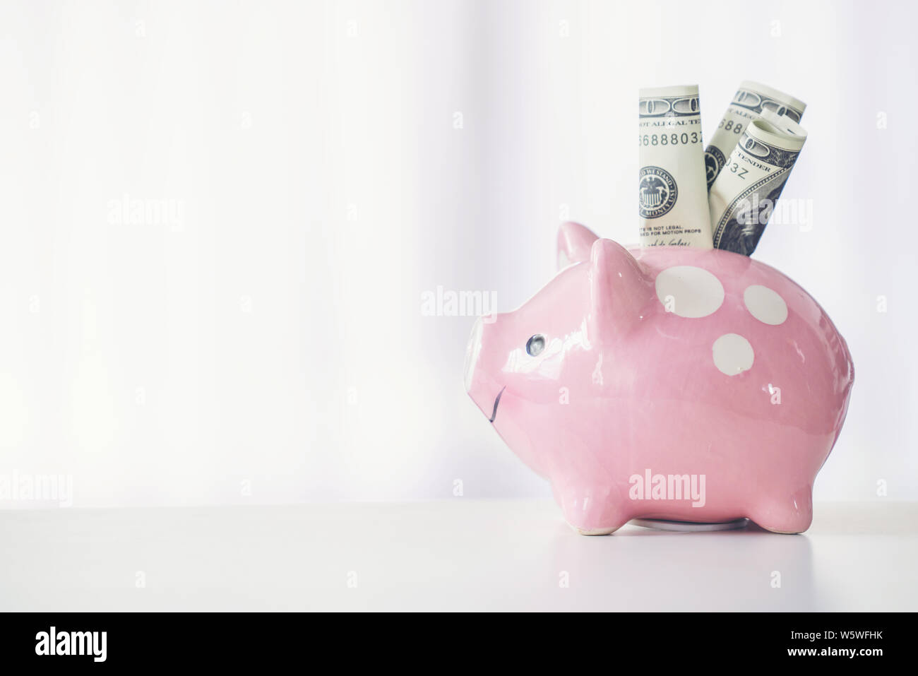 pink color piggy bank on white table, saving concept Stock Photo