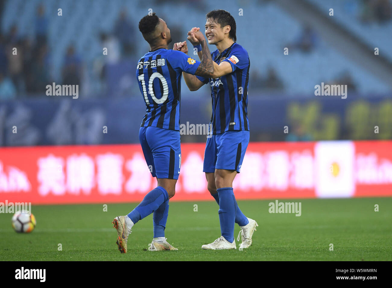 Brazilian football player Alex Teixeira, left, and Wang Song of Jiangsu Suning celebrate after scoring a goal against Henan Jianye in their 30th round Stock Photo