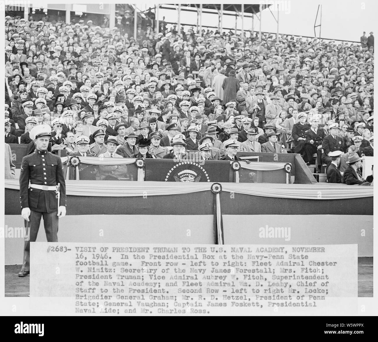 Photograph of the presidential box at the Penn State-Navy football game, during President Truman's visit to the U.S. Naval Academy; Scope and content:  Photograph of the presidential box at the Penn State-Navy football game, during the President's visit to the U.S. Naval Academy: (front row, left to right) Fleet Admiral Chester W. Nimitz; Secretary of the Navy James Forrestal; Mrs. Aubrey Fitch; the President; Vice Admiral Aubrey Fitch, Superintendent of the Naval Academy; and Fleet Admiral William D. Leahy (second row, left to right) White House aide Edwin Locke, Jr.; General Wallace Graham, Stock Photo