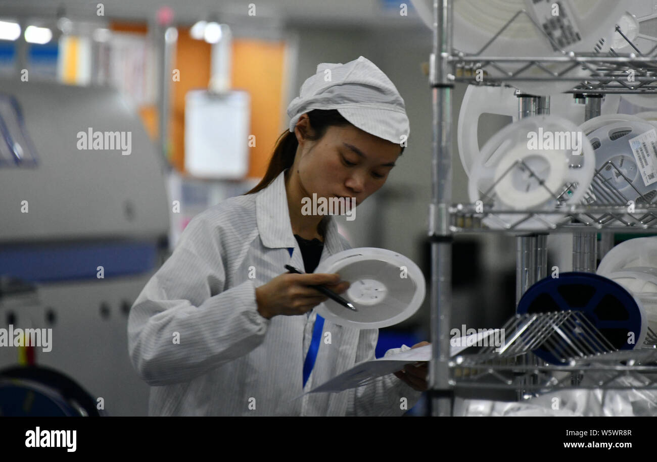 A Chinese worker checks intelligent products on the assembly line at a ...