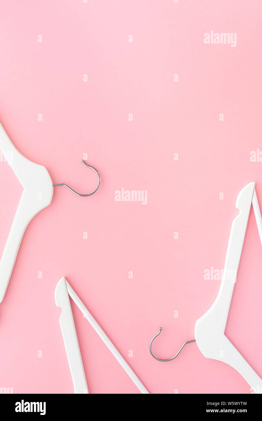 Creative top view flat lay white wooden hangers pastel millennial pink ...