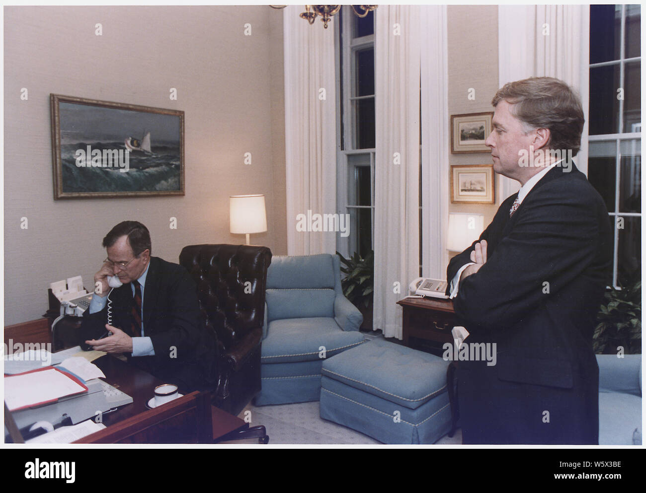 President Bush talks to Egyptian President Hosni Mubarak in the Oval Office Study about the commencement of Operation Desert Storm. Vice President Quayle is present during the call Stock Photo