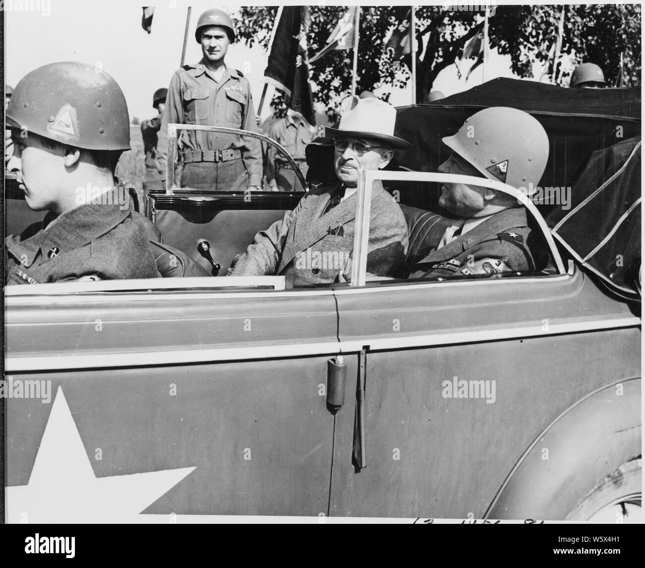 President Harry S. Truman is sitting in a sedan with Brig. Gen. Doyle O. Hickey, Commanding General of the 3rd Armored Division during the President's visit to inspect troops in Neuisenburg, Germany. The President has just left the Potsdam Conference for a quick tour of the American occupied area. Stock Photo