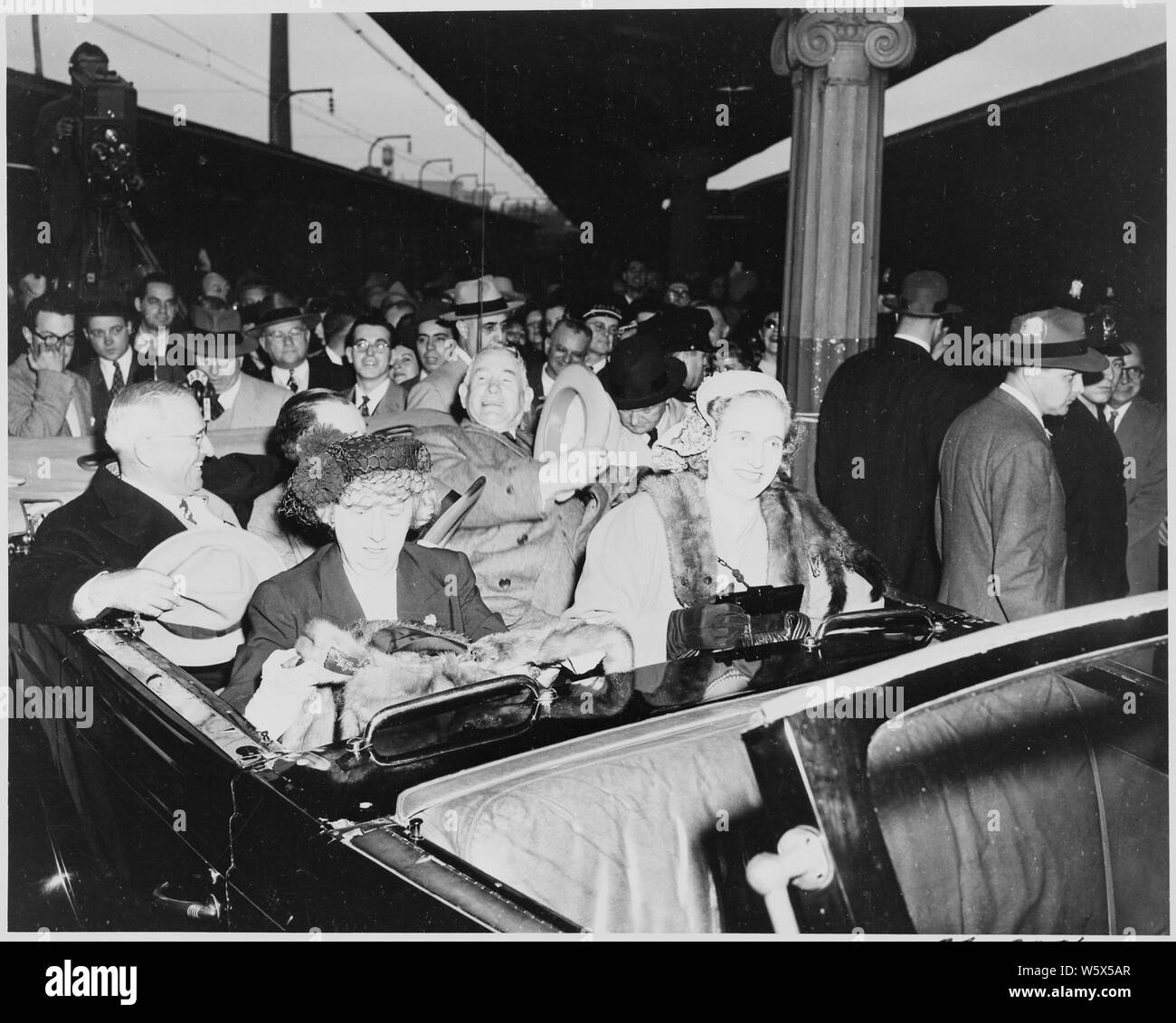 President Harry S. Truman, Vice President-elect Alben W. Barkley, Bess Truman, and Margaret sitting in an open car in the Washington, DC train station. Truman and Barkley had just returned to Washington after their victory in the 1948 election. Stock Photo