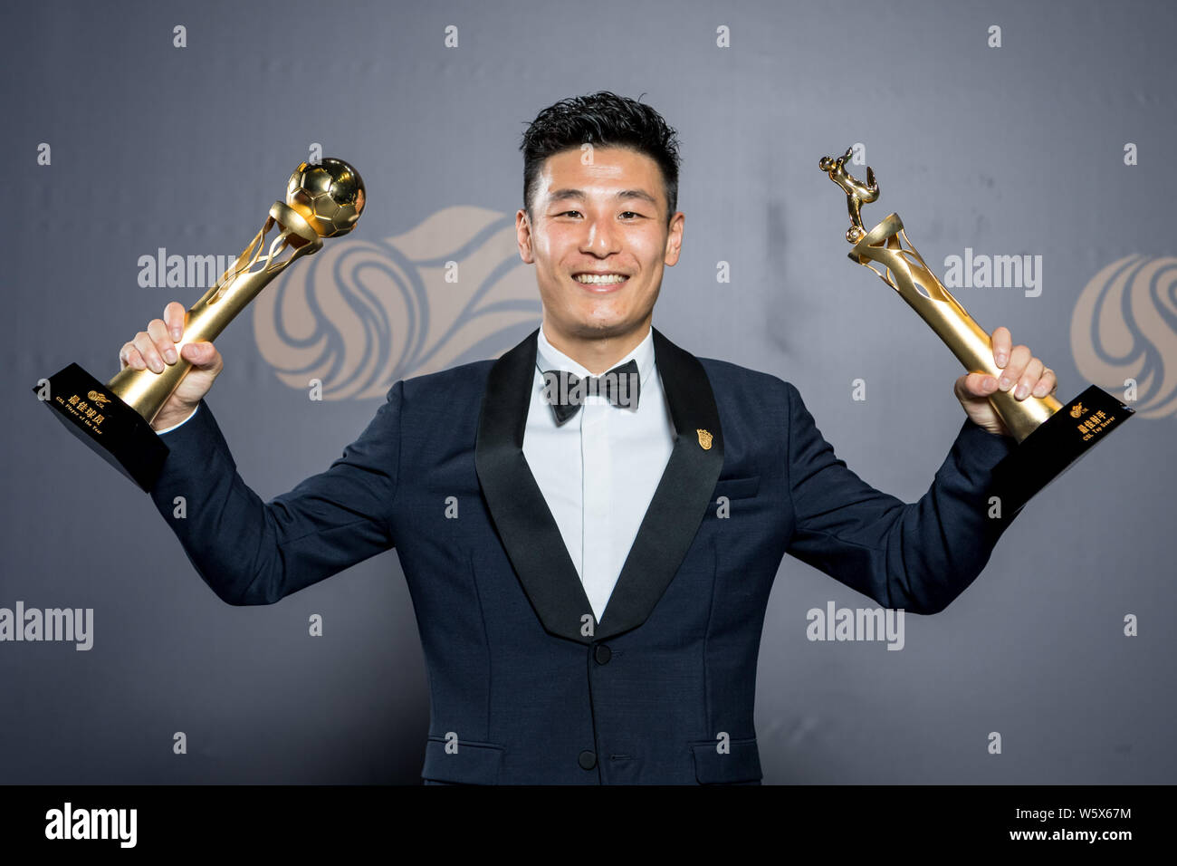 Chinese football player Wu Lei of Shanghai SIPG poses with trophys for the CSL Top Scorer and Player of the Year Awards at the 2018 Chinese Super Leag Stock Photo