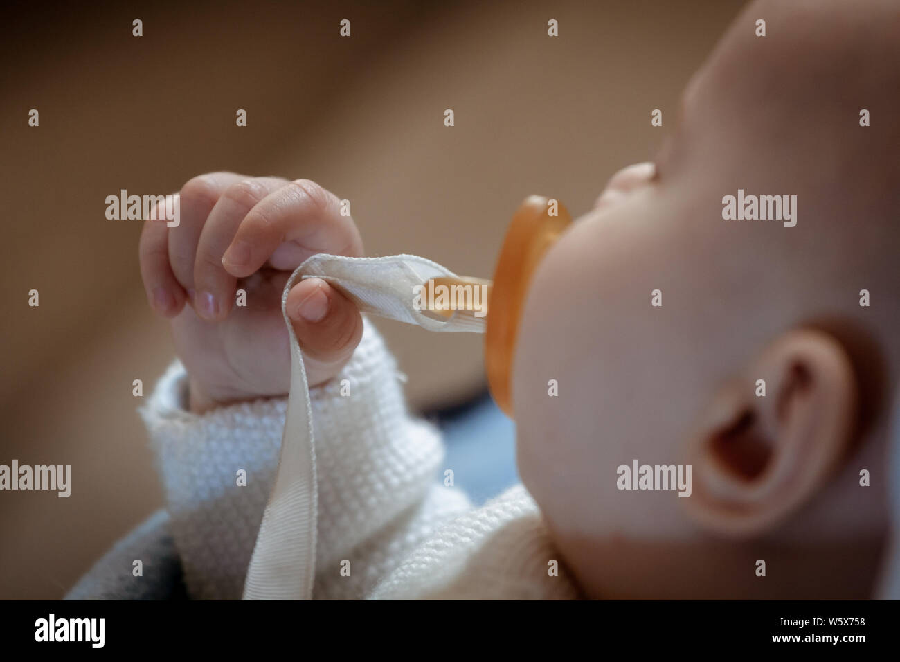 Beautiful little newborn sleeping sucking the pacifier. Focus on the