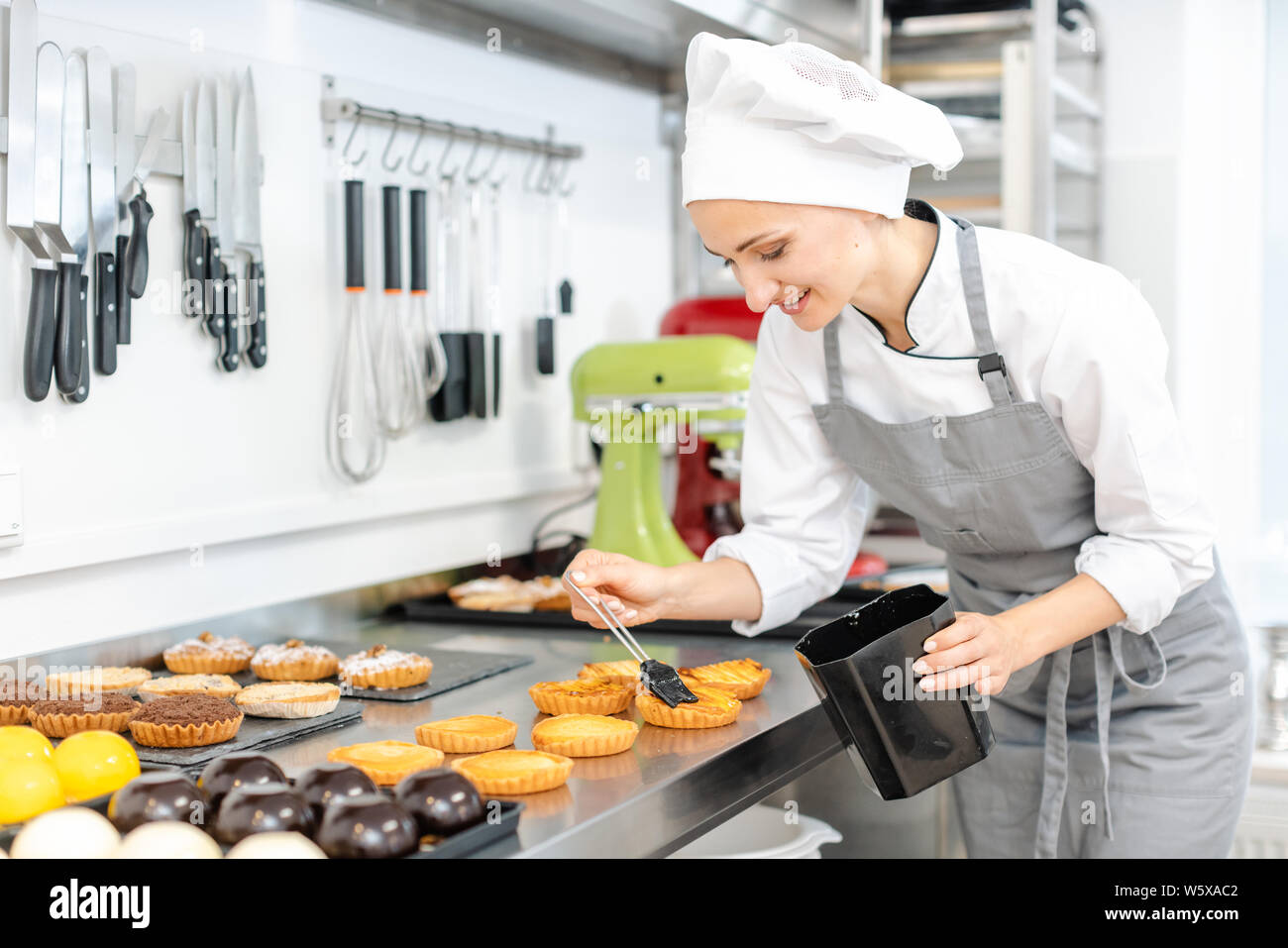 Pastry chef glazing little cakes Stock Photo