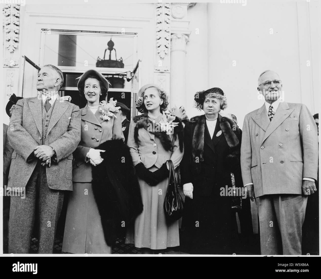 President and Mrs. Harry S. Truman, Vice President-elect Alben W. Barkley, Mrs. Max Truitt, and Margaret Truman Daniel standing on the front porch of the White House. Truman and Barkley had just returned to Washington, DC after their victory in the 1948 election. Stock Photo