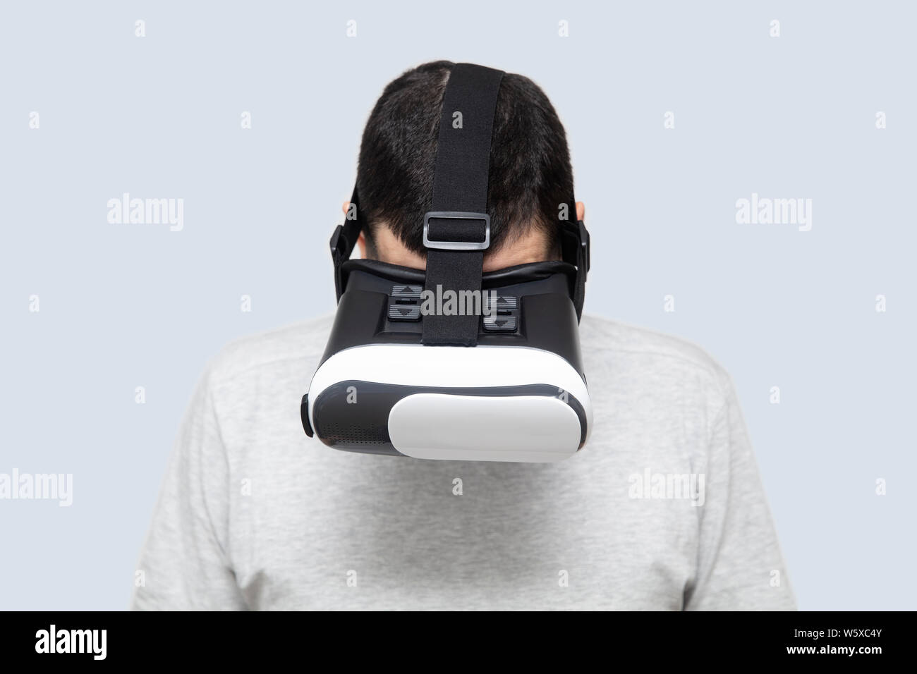 Young man using vr headset in studio, experiencing virtual reality Stock Photo
