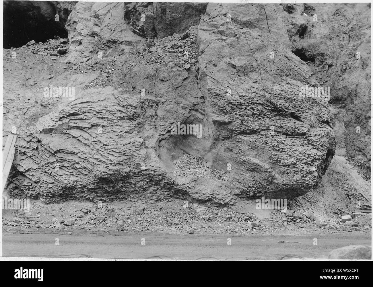 Pressure structure cleavage developed along the walls of the canyon. This structure which produces thin slabs or cleavage plates nearly parallel to the free surface is believed to be due to the removal of supports, by reason of erosion of the canyon, in rock under great strain. This is an attempt at readjustment.; Scope and content:  Photograph from Volume Two of a series of photo albums documenting the construction of Hoover Dam, Boulder City, Nevada. Stock Photo